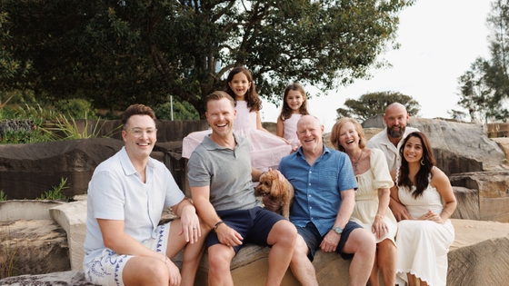 Our gift in Will supporter, Pam, and her intergenerational family sitting at the beach